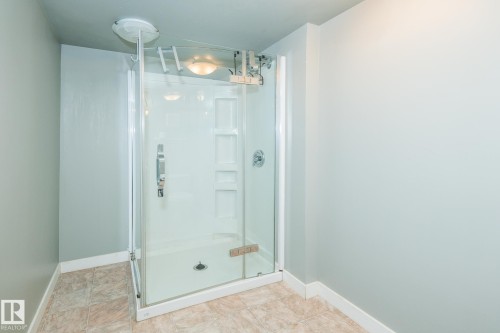 Enclosed shower stall with clear glass door and integrated shelving - 7543 149A Avenue, Edmonton, AB 