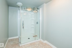 Enclosed shower stall with clear glass door and integrated shelving - 