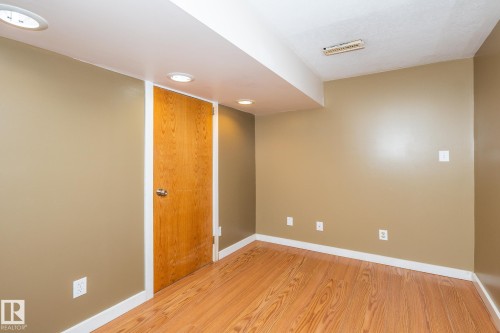 Room featuring wood-finish flooring, recessed lighting, and a neutral wall color - 7543 149A Avenue, Edmonton, AB 