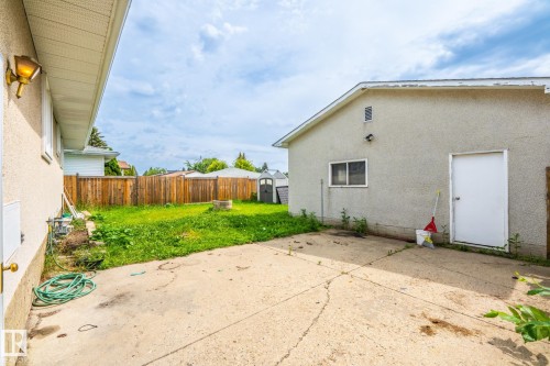 Spacious concrete patio and grassy yard area, enclosed by a wood privacy fence - 7543 149A Avenue, Edmonton, AB 