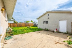 Spacious concrete patio and grassy yard area, enclosed by a wood privacy fence - 