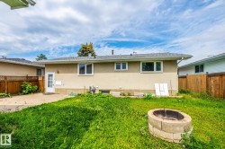 Rear exterior of the property featuring a stucco finish and a shingled roof - 
