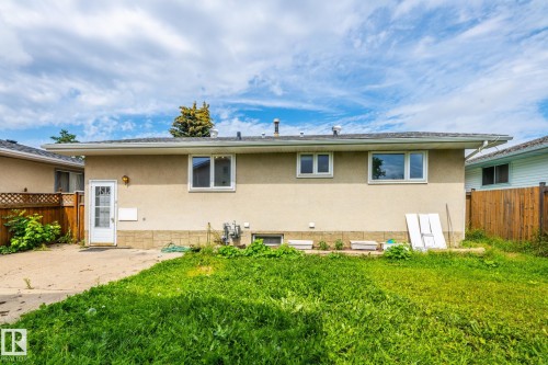 Rear exterior featuring stucco siding, a shingle roof, and multiple windows - 7543 149A Avenue, Edmonton, AB 