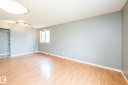 Open room featuring wood-finish flooring, light grey walls, and a white ceiling - 