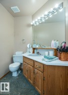 Bathroom featuring a wood-finish vanity with a white countertop and integrated sink - 