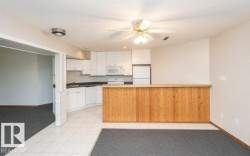 Compact kitchen featuring white cabinetry, dark countertops, and white appliances - 