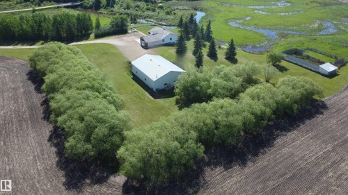 Expansive aerial view showcasing a large property with multiple structures, surrounded by natural landscaping - 60230 Rg Rd 271, Rural Westlock County, AB 