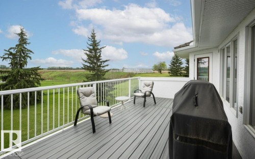 Expansive elevated deck featuring composite decking, white aluminum railing, and direct access to interior spaces through a white-framed glass door - 60230 Rg Rd 271, Rural Westlock County, AB 