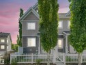 Duplex-style residence featuring a white picket fence, a pedestrian gate, and a covered porch - 77 4050 Savaryn Drive, Edmonton, AB 