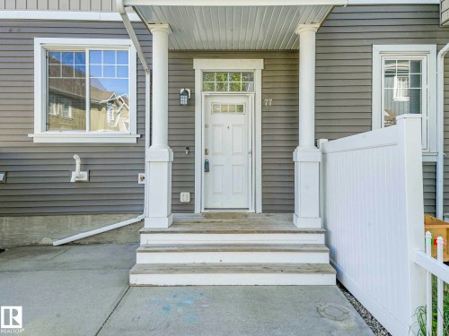 Inviting entry featuring a white paneled door with transom window, flanked by decorative columns - 77 4050 Savaryn Drive, Edmonton, AB 