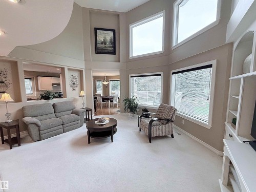 Two-story living area with high ceilings, multiple large windows, and an open concept layout - 915 Picard Drive Nw, Edmonton, AB 