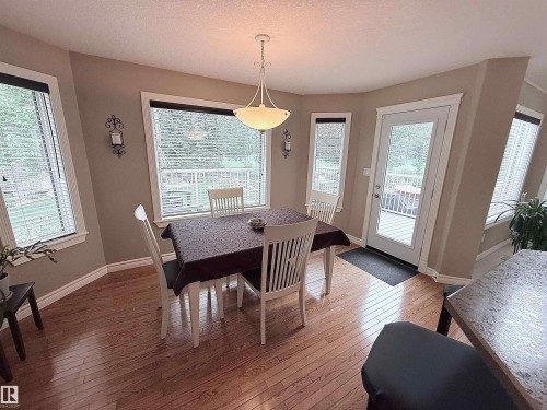 Dining area featuring wood-finish flooring and a central pendant light fixture - 915 Picard Drive Nw, Edmonton, AB 