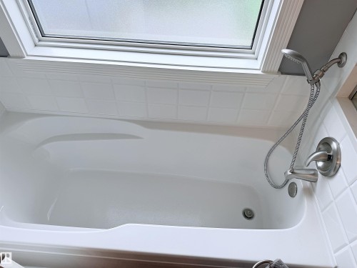 White bathtub with brushed nickel shower fixtures and a handheld spray - 915 Picard Drive Nw, Edmonton, AB 