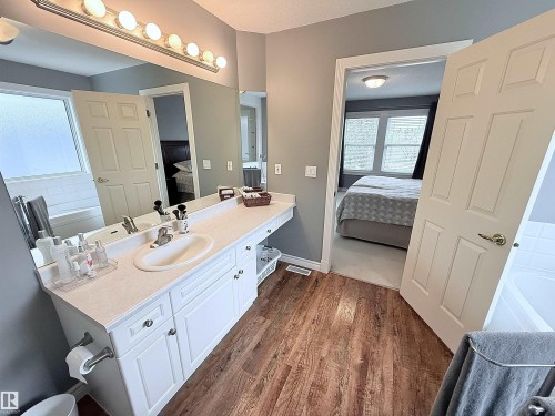 Bathroom featuring a spacious vanity with a single basin sink, extensive countertop space, and white cabinetry - 915 Picard Drive Nw, Edmonton, AB 