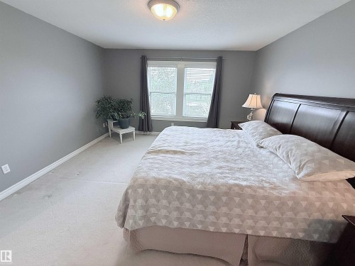 Spacious room featuring light-colored carpet flooring, a window with horizontal blinds, and a flush-mount ceiling light fixture - 915 Picard Drive Nw, Edmonton, AB 
