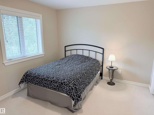 Carpeted room featuring a window with horizontal blinds, light-toned walls, and white trim - 915 Picard Drive Nw, Edmonton, AB 
