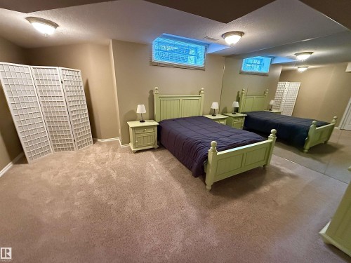 Carpeted room featuring neutral-toned walls, recessed windows, and flush-mount ceiling lighting - 915 Picard Drive Nw, Edmonton, AB 