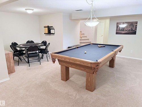 Spacious lower level featuring plush carpeting, recessed lighting, and a prominent central light fixture - 915 Picard Drive Nw, Edmonton, AB 