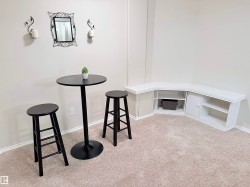 Built-in corner cabinetry with open shelving and closed storage, complemented by light-colored carpeting - 