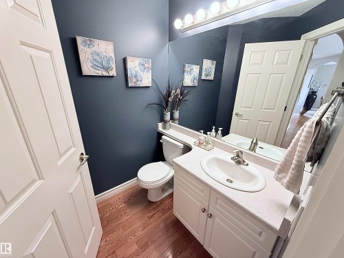 Bathroom featuring a white vanity with integrated sink, a rectangular mirror, and an overhead vanity light fixture - 915 Picard Drive Nw, Edmonton, AB 