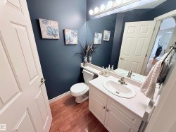 Bathroom featuring a white vanity with integrated sink, a rectangular mirror, and an overhead vanity light fixture - 