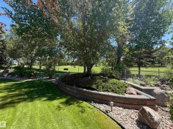 Manicured lawn with a curved paver retaining wall and integrated landscaping - 