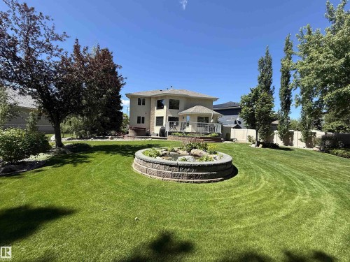 Expansive green lawn with a circular stone-edged garden bed - 915 Picard Drive Nw, Edmonton, AB 