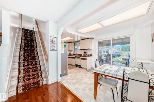 Staircase featuring a patterned runner and wood handrail - 6804 102A Avenue, Edmonton, AB 