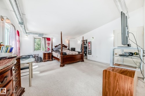 Carpeted room with white walls, two windows, and exposed ductwork - 6804 102A Avenue, Edmonton, AB 