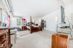 Carpeted room with white walls, two windows, and exposed ductwork - 