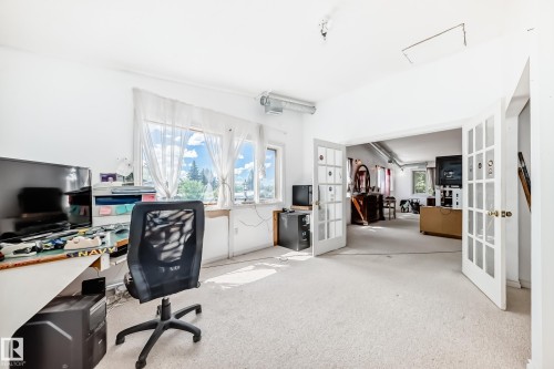 Room featuring light-colored carpeting, multiple windows providing natural light, and white walls - 6804 102A Avenue, Edmonton, AB 