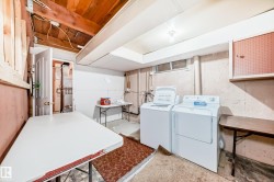 Equipped laundry area featuring a freestanding washer and dryer, exposed wood ceiling beams, a utility sink, and a high-set window - 