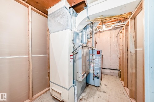 Utility area featuring a furnace and water heater installation - 6804 102A Avenue, Edmonton, AB 