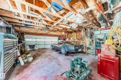 Garage space featuring an exposed wood beam ceiling, concrete flooring, and multiple storage options - 