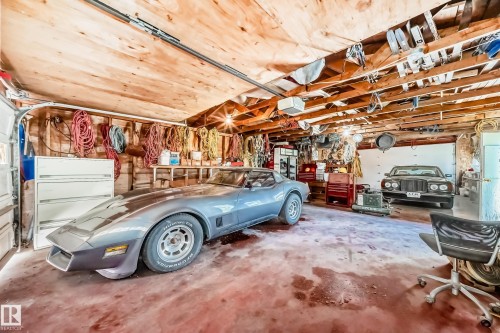 Garage interior featuring exposed wood ceiling beams and wood paneling - 6804 102A Avenue, Edmonton, AB 