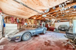 Garage interior featuring exposed wood ceiling beams and wood paneling - 