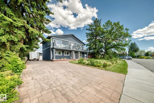 Stucco exterior with a second-story balcony featuring glass railings - 6804 102A Avenue, Edmonton, AB 