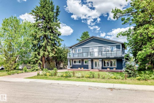 Two-story residence featuring a dark blue facade with contrasting white trim - 6804 102A Avenue, Edmonton, AB 