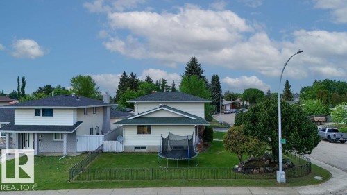 Corner lot property featuring a two-story home with a light-colored exterior and contrasting dark roof - 712 Lee Ridge Road, Edmonton, AB 