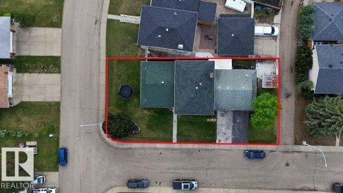 Corner lot property featuring a large grassy yard, mature tree, and a concrete driveway - 712 Lee Ridge Road, Edmonton, AB 