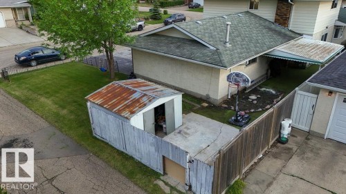 Rear exterior featuring a detached storage shed, privacy fencing, and a covered patio area - 712 Lee Ridge Road, Edmonton, AB 
