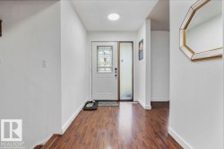 Entryway featuring wood-finish flooring, a white entry door with decorative glass, and a frosted glass sidelight - 
