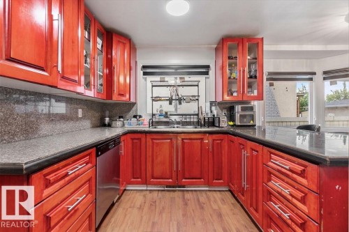 Kitchen featuring rich wood cabinetry, stone countertops, and wood-finish flooring - 712 Lee Ridge Road, Edmonton, AB 