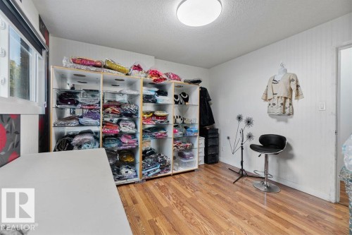 Bright interior room featuring wood-finish flooring, white walls, and a large window providing natural light - 712 Lee Ridge Road, Edmonton, AB 