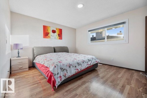 Bedroom featuring wood-finish flooring, a contemporary window, and a recessed ceiling light - 712 Lee Ridge Road, Edmonton, AB 