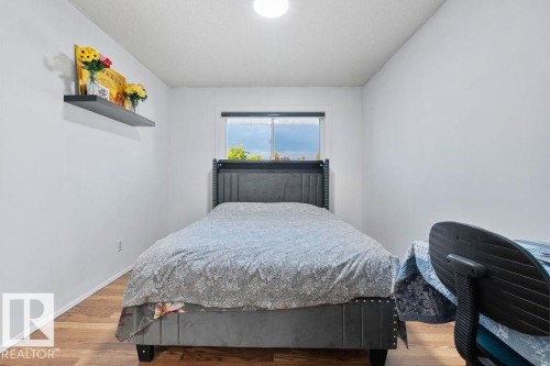 Bright room featuring wood-finish flooring, a window, and a built-in wall shelf - 712 Lee Ridge Road, Edmonton, AB 
