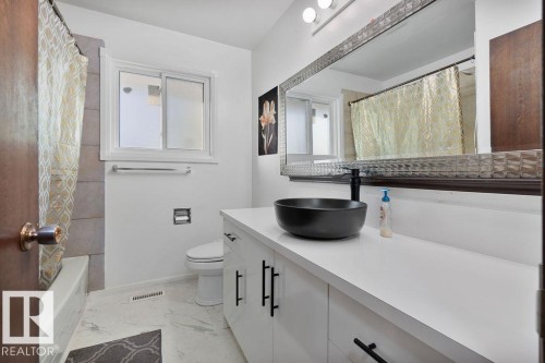 Bathroom featuring a white vanity with black hardware, a black vessel sink, and a black faucet - 712 Lee Ridge Road, Edmonton, AB 