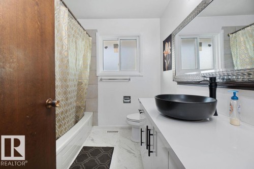 Bathroom vanity with a black vessel sink, black faucet, and white countertop - 712 Lee Ridge Road, Edmonton, AB 