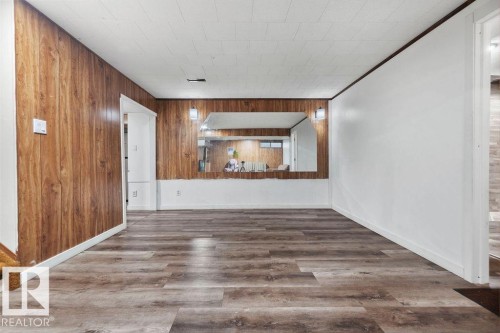 Spacious room featuring wood-finish flooring, wood paneling, and white painted walls - 712 Lee Ridge Road, Edmonton, AB 