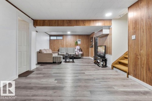 Spacious lower-level area featuring wood-finish flooring, recessed lighting, and a drop panel ceiling - 712 Lee Ridge Road, Edmonton, AB 